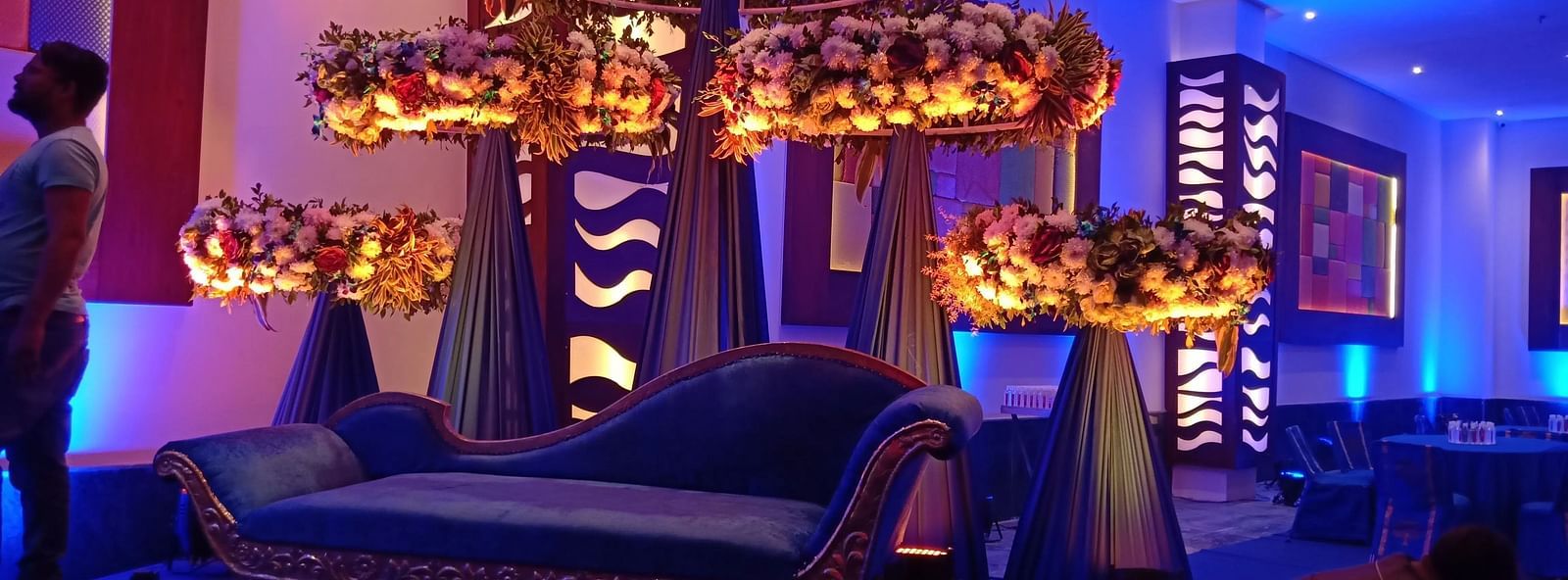 Indoor lounge with ornate chandeliers, lights, and seating.