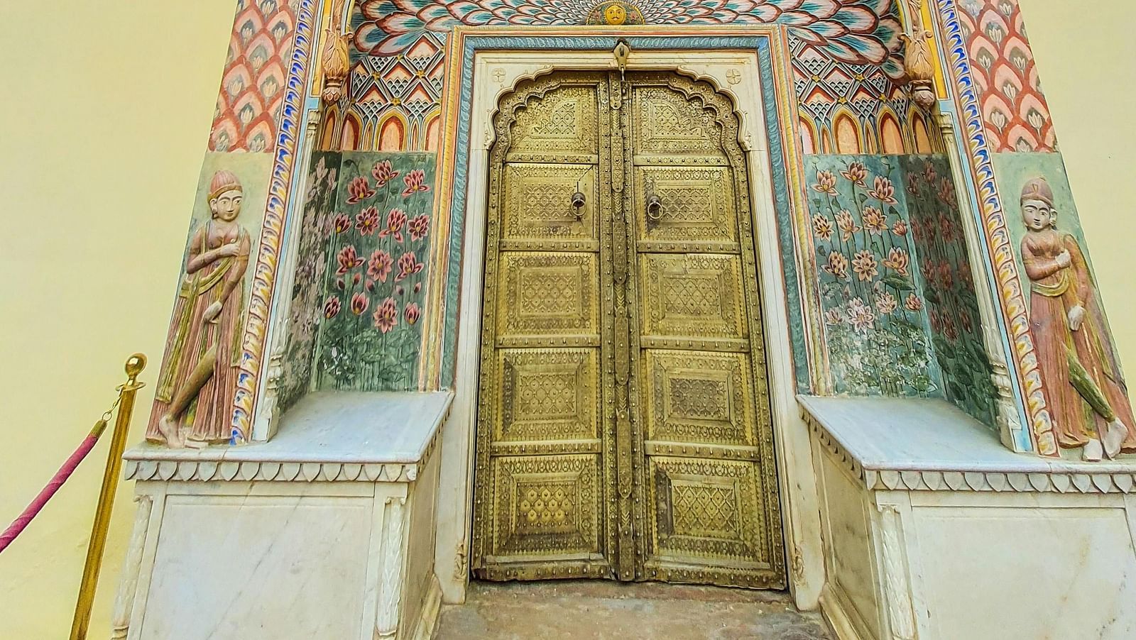 A low angle shot of a door featuring the porch and the upper level of the building with intricate design