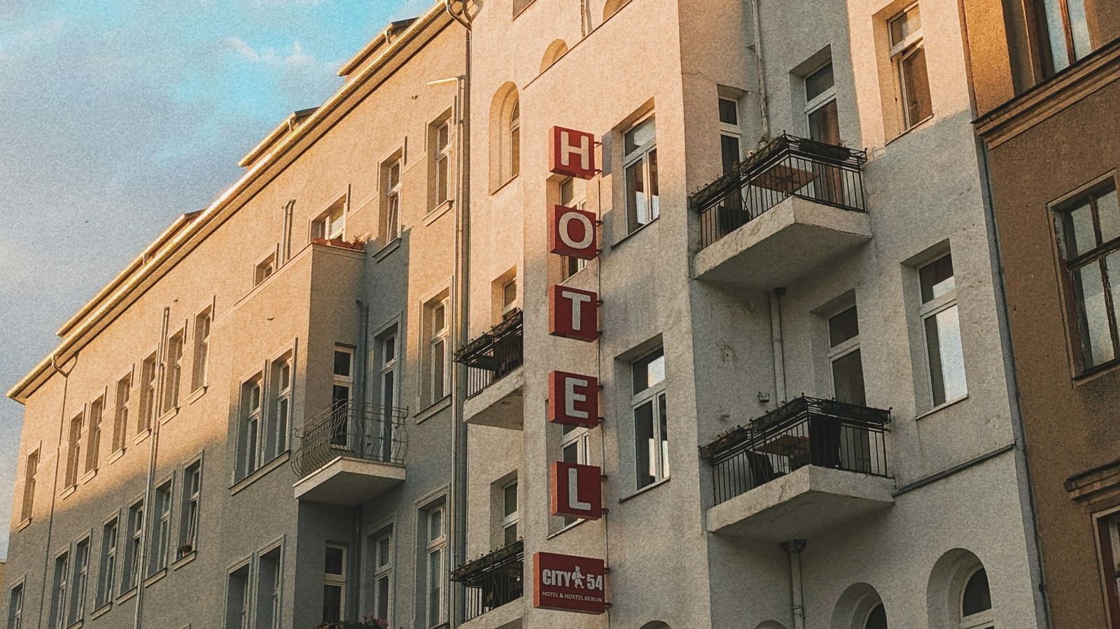  A low-angle view of a row of European-style buildings with balconies under a blue sky