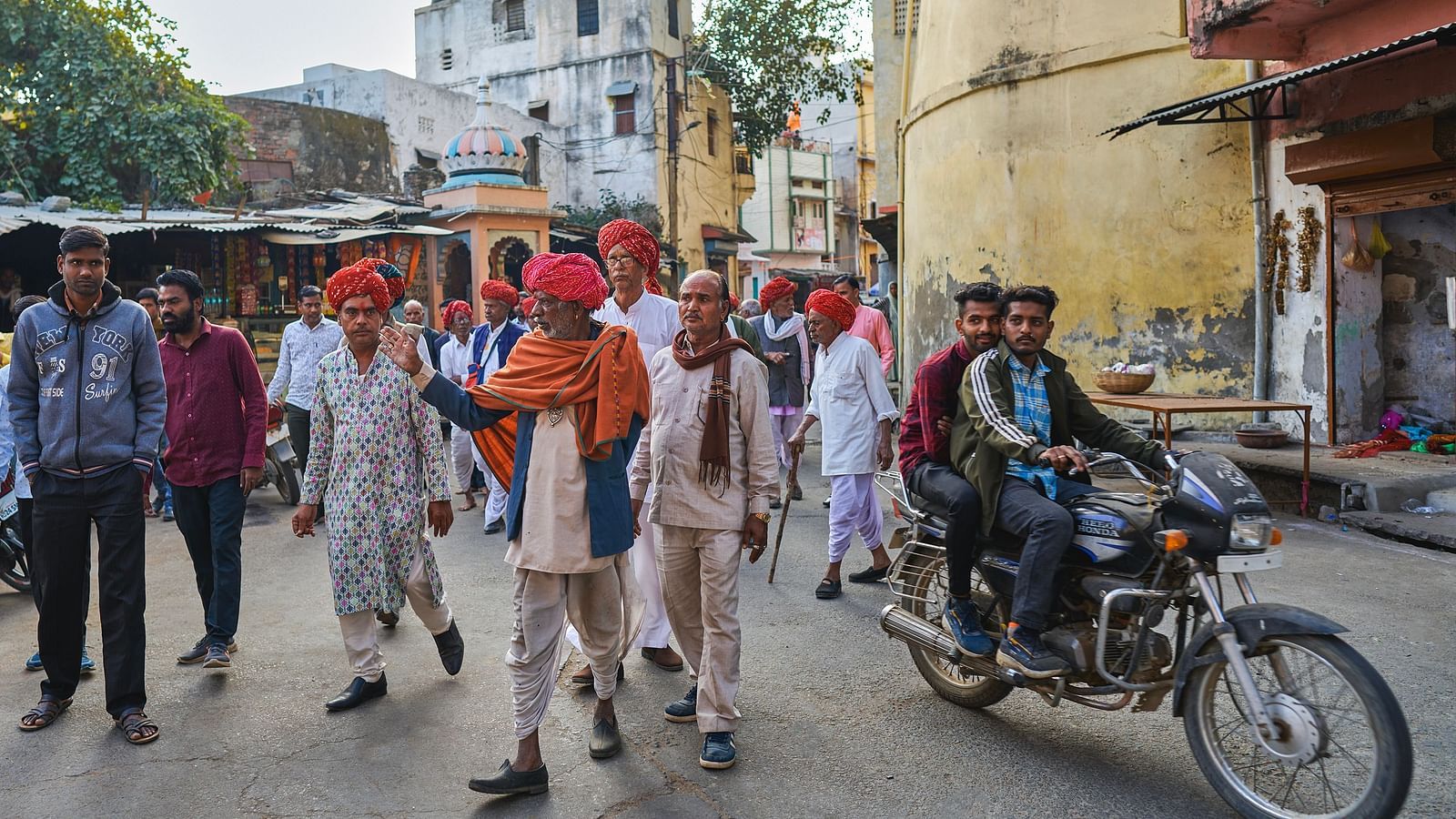 image of a group of local rajasthani men walking in the streets of the city wearing a pink traditional turban on their heads