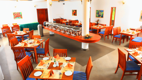 Peppermint Restaurant at Abad Green Forest, one of the finest restaurants in Thekkady, featuring buffet counters, wooden tables, and comfortable seating.