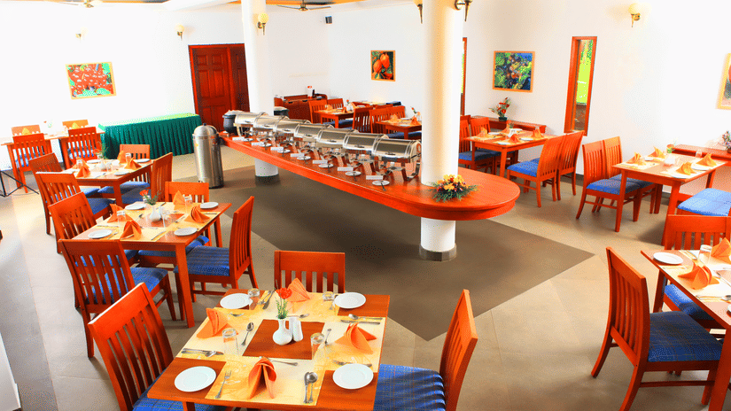 Peppermint Restaurant at Abad Green Forest, one of the finest restaurants in Thekkady, featuring buffet counters, wooden tables, and comfortable seating.