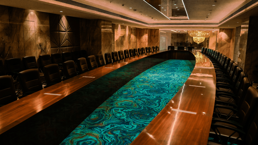 The modern conference room of Allure hall featuring a glossy wooden table with rows of matching office chairs at Praveg's Grand Eulogia, Ahmedabad.
