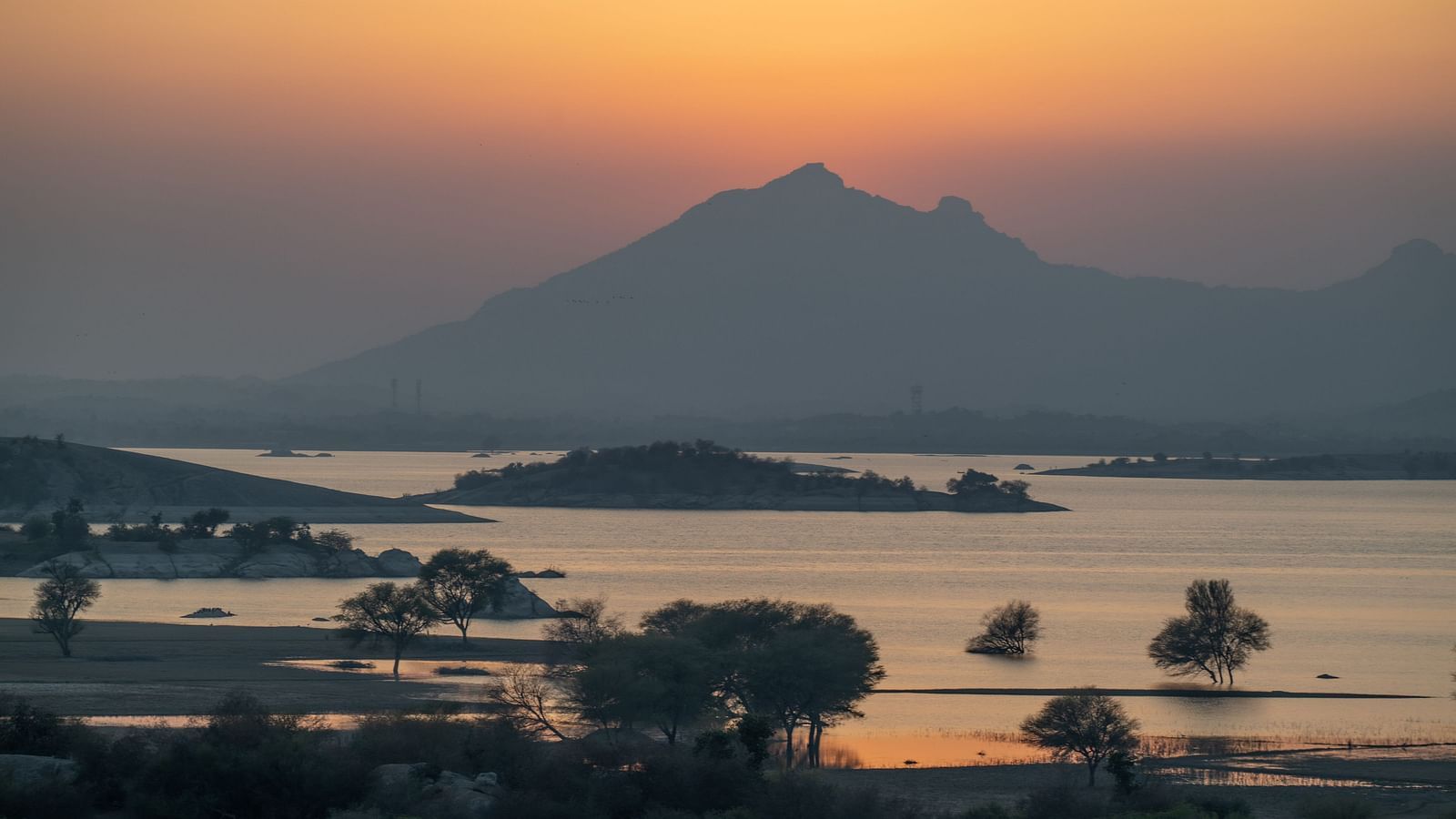 A riverside mountain view during the golden hour.