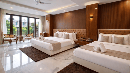 A Family Suite AC Room at Valmere Chery Blossom Suites featuring 2 plush beds, 2 matching rugs, an accent wall with wood panelling, and large windows.