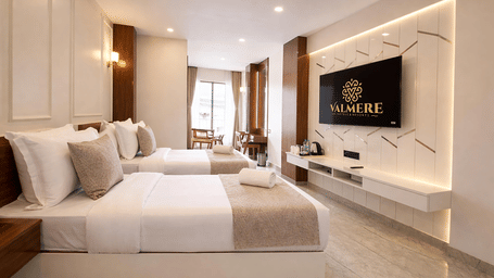 A spacious Premium Twin Room at Valmere Chery Blossom Suites featuring 2 twin beds, a wall-mounted television, and elegant modern furnishing.