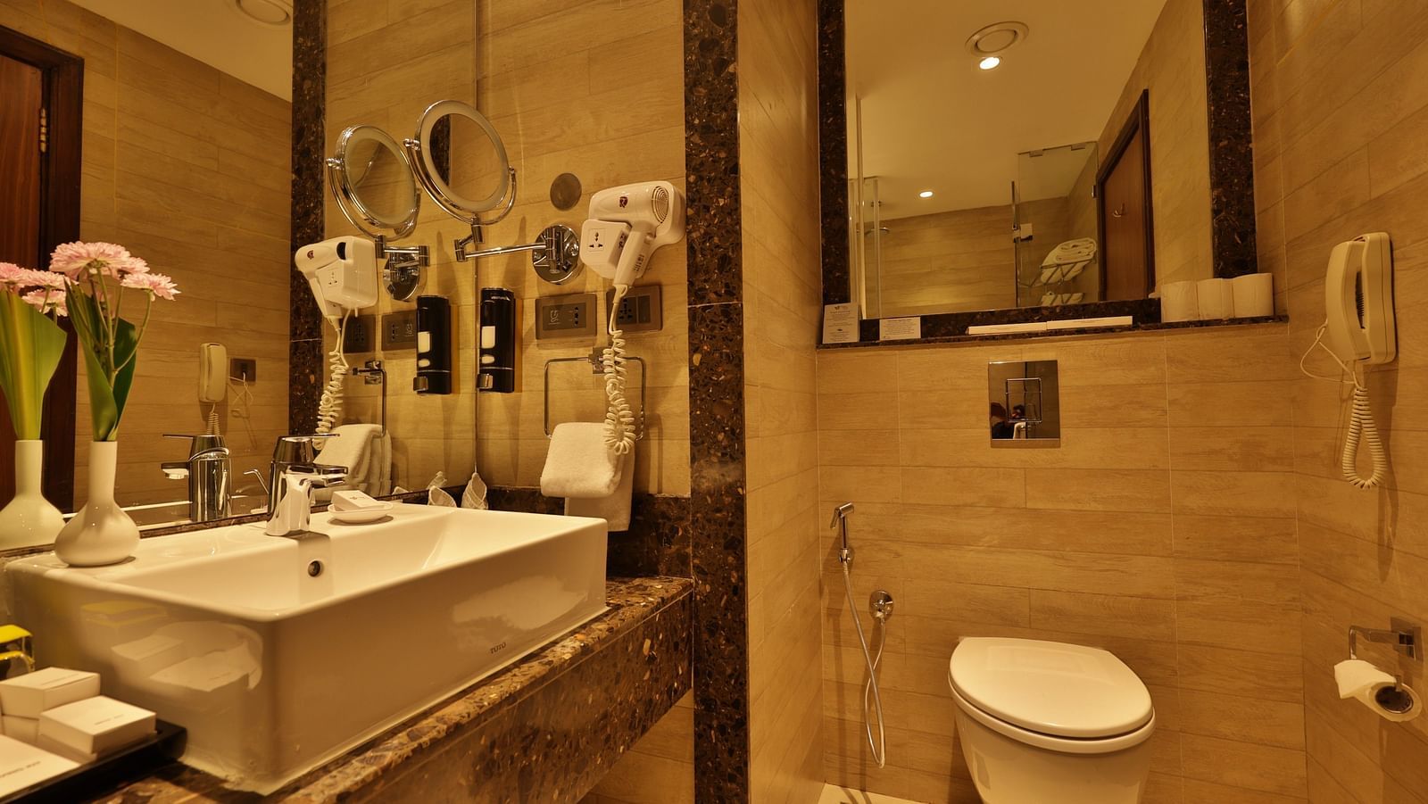 Standard Tropic Green Room with Partial Mountain View bathroom featuring dual sinks, decorative orchids, and a sleek design at Fragrant Nature Munnar