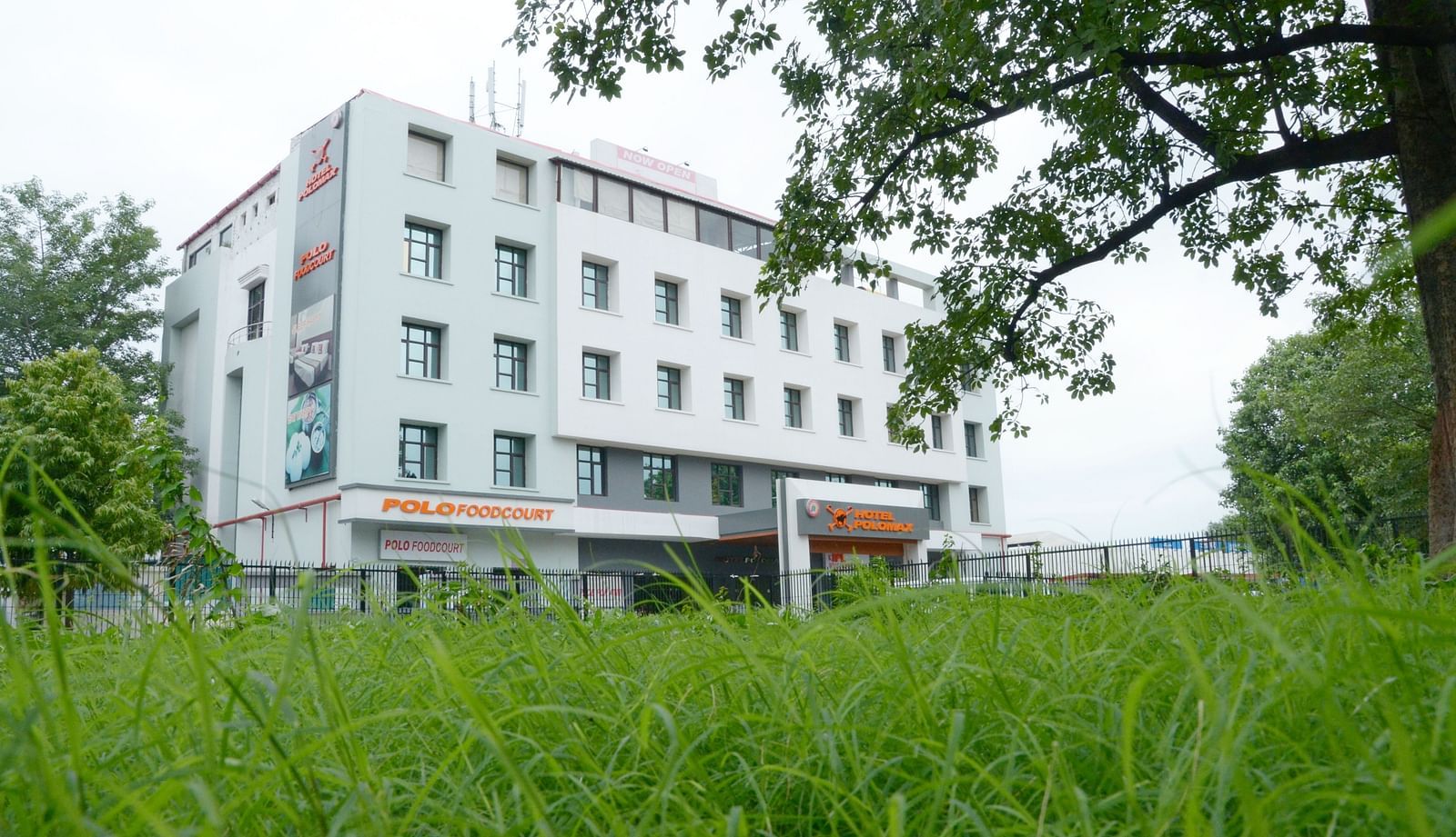 Facade view of Max Hotel Prayagraj surrounded by greenery.