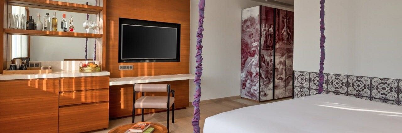 Luxury room with television, furniture and a private bar - Azaya Beach Resort Goa