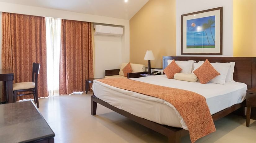 The king size bed in the premier room with peach coloured blanket at Kyriad Prestige Calangute, Goa