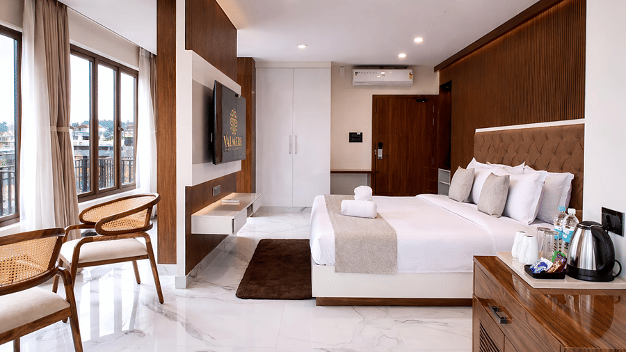 A Junior Suite AC Room at Valmere Chery Blossom Suites featuring a plush bed, a comfortable seating area, and elegant modern interiors.