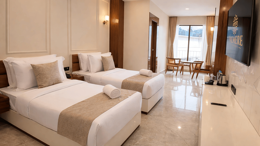 An elegant Premium Twin Room at Valmere Chery Blossom Suites featuring 2 twin beds, a large window and a seating area next to it. 