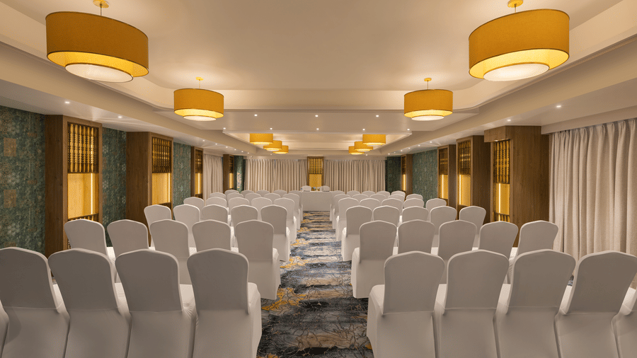 A convention hall with chairs, tables, chandeliers, and carpet. | Essentia Luxury Hotel and Convention, Nagpur