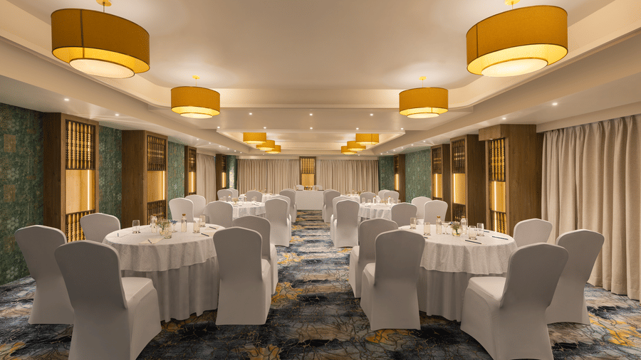 A convention hall with chairs, tables, chandeliers, and carpet. | Essentia Luxury Hotel and Convention, Nagpur