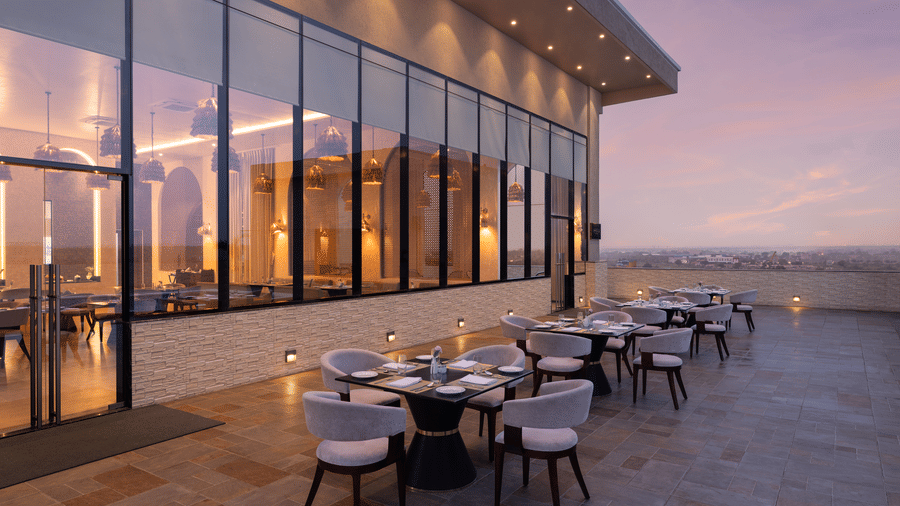 A dining space with several chairs and tables | Essentia Luxury Hotel and Convention, Nagpur