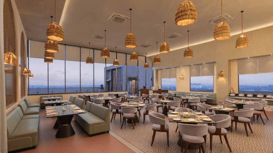 A dining space with several chairs and tables | Essentia Luxury Hotel and Convention, Nagpur