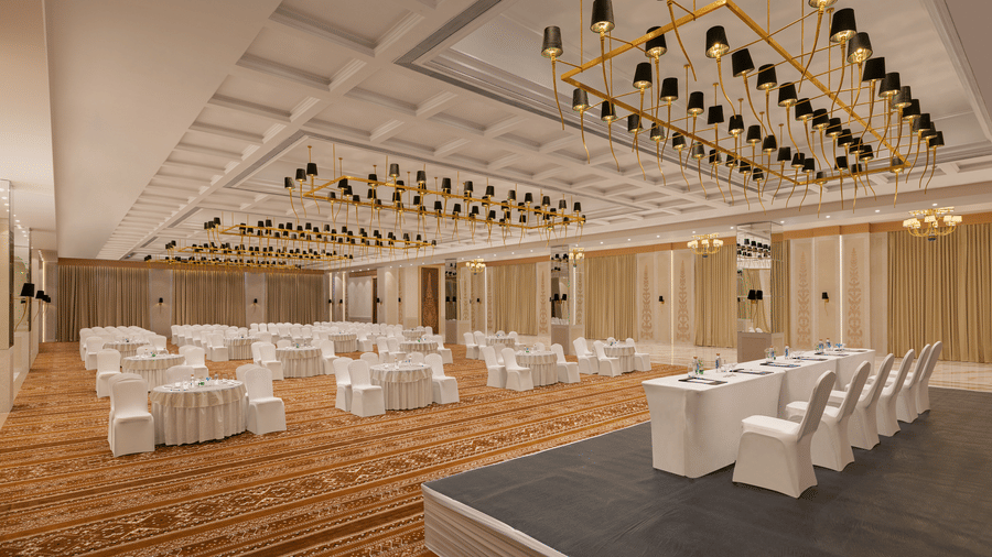 A convention hall with chairs, tables, and carpet. | Essentia Luxury Hotel and Convention, Nagpur