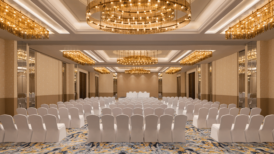 A convention hall with chairs, chandeliers, and carpet. | Essentia Luxury Hotel and Convention, Nagpur