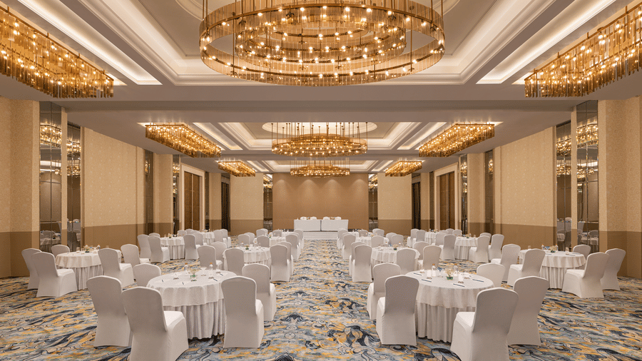 A convention hall with chairs, chandeliers, and carpet. | Essentia Luxury Hotel and Convention, Nagpur