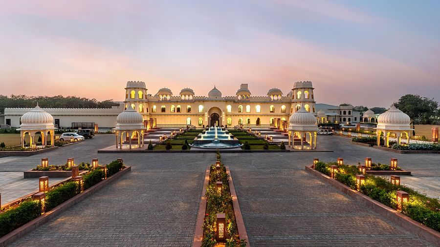 Exterior view of Kesar Bagh Palace building at sunset with landscaped pathways.