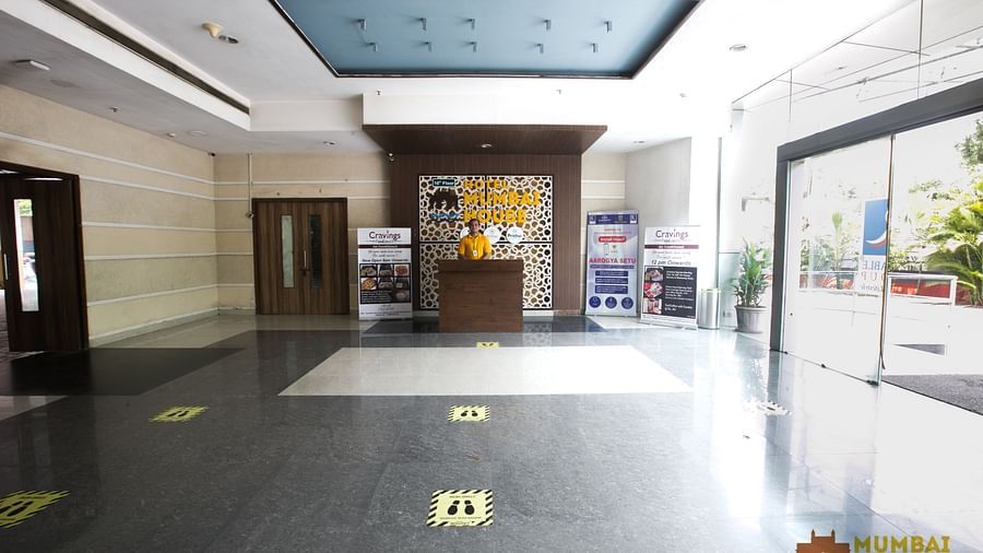 Hotel lobby with a reception desk, social distancing markers and promotional displays.