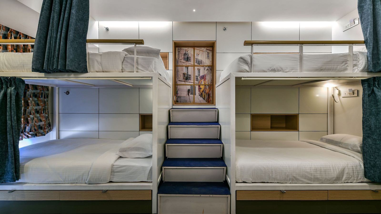 An image of dormitory room featuring beds on upper and lower berths and there is a flight of stairs leading to beds on top - Indie Stays, Chembur.