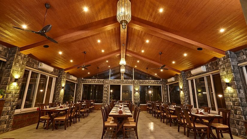 Spacious indoor restaurant with high ceiling and symmetrical table arrangements for dining - Mastiff Grand La Villae Resort, Lonavala