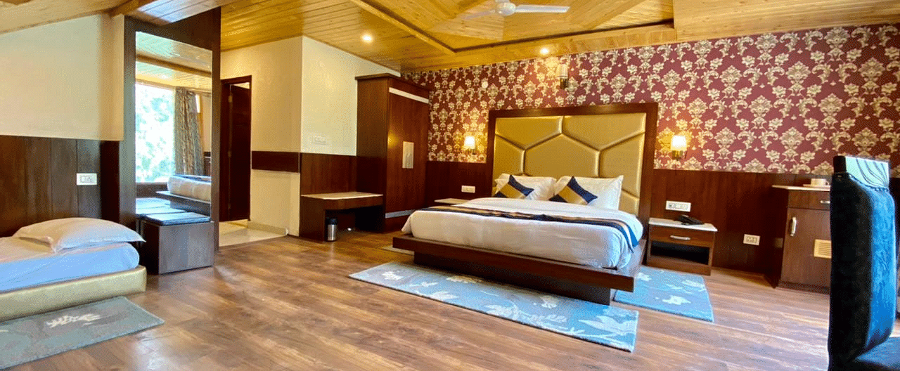 A spacious room at La Serene Valley, Manali, with a king sized bed, seating area, and large windows inviting natural light.
