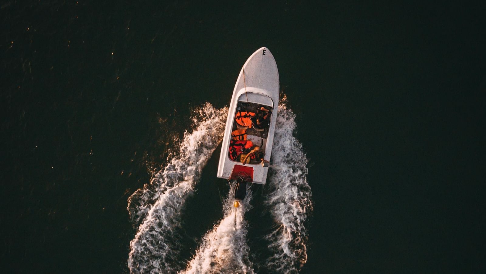 Aerial view of a boat with people wearing life jackets.