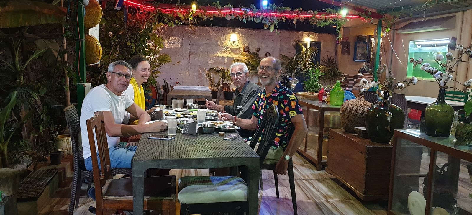 Few guests smiling towards the camera as they are sitting in the dining area of the Dream Vision Guest House.
