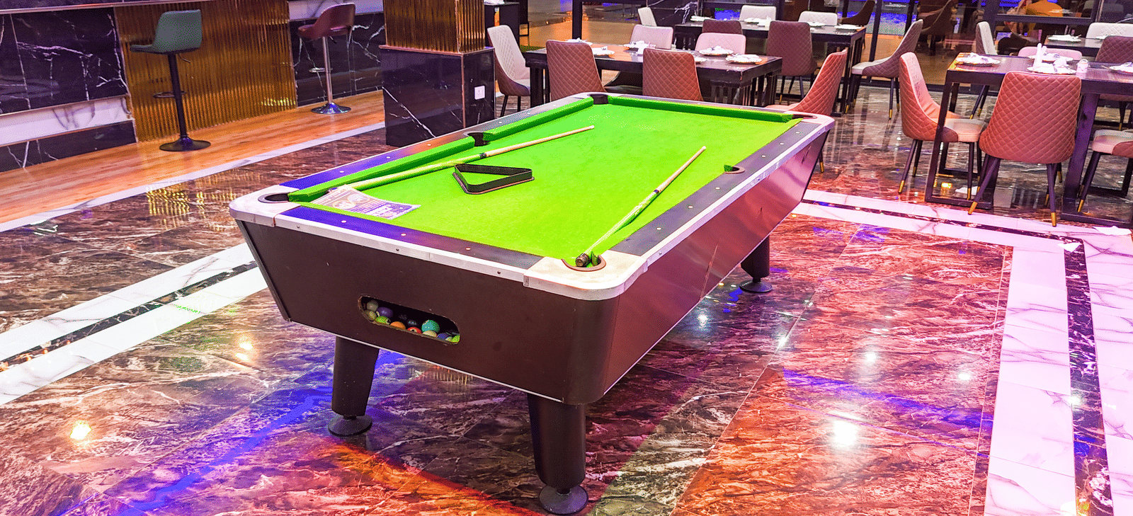 Interior view of a lounge area with a small pool table - Luffu Club