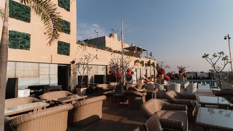 An outdoor seating area, possibly at a restaurant with tables and chairs at Hotel Ashok Nagpur.