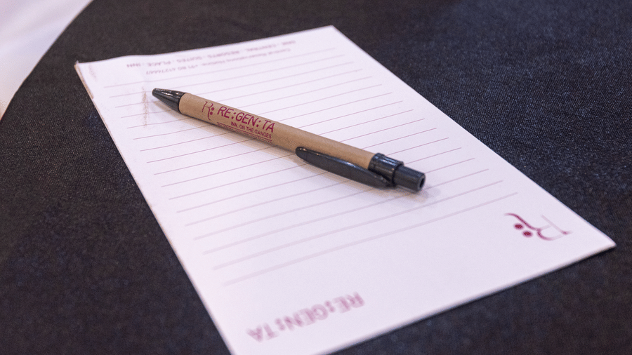 A paper and a pen on a black surface with DLS Hotels On The Ganges logo.