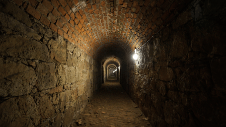 A view from inside a tunnel with bricks above and large stones holding them at Cu Chi Tunnels. These tunnels are one of the ideal places to visit on your trips from Ho Chi Minh City.