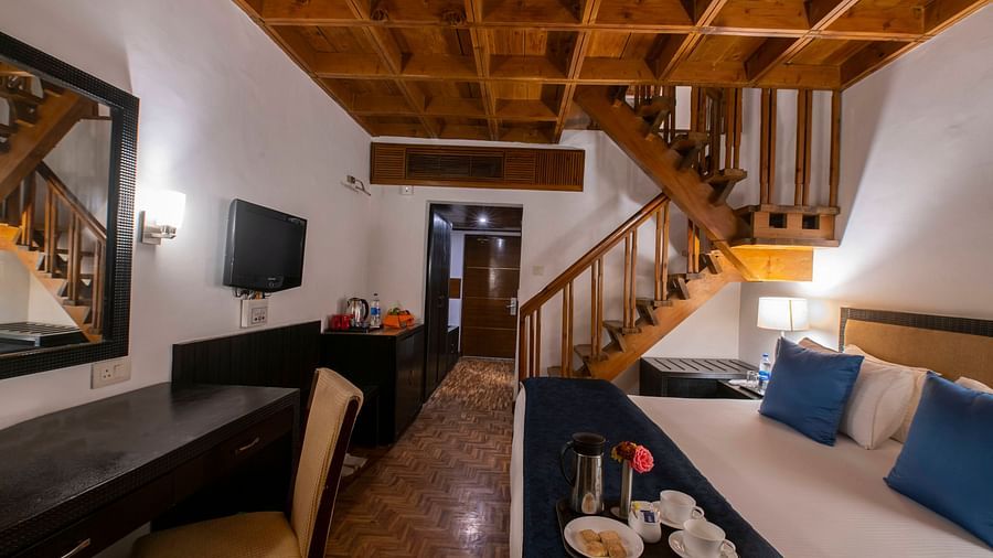 A room featuring stairs bed vanity and cabinets - Mastiff Grand Manali