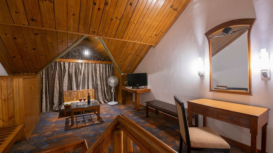 A spacious living room featuring sitting arrangements a TV and a miroor - Mastiff Grand Manali