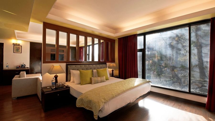 a view of a bed in Suite decked with a bed with yellow duvet at Mastiff Grand, Manali