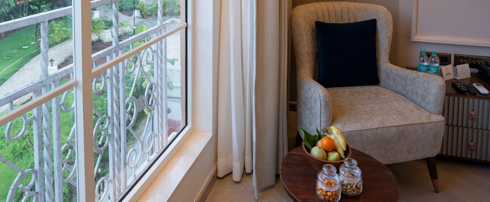Cosy seating, overlooking greenery through a window area with natural light at Miros Hotels.