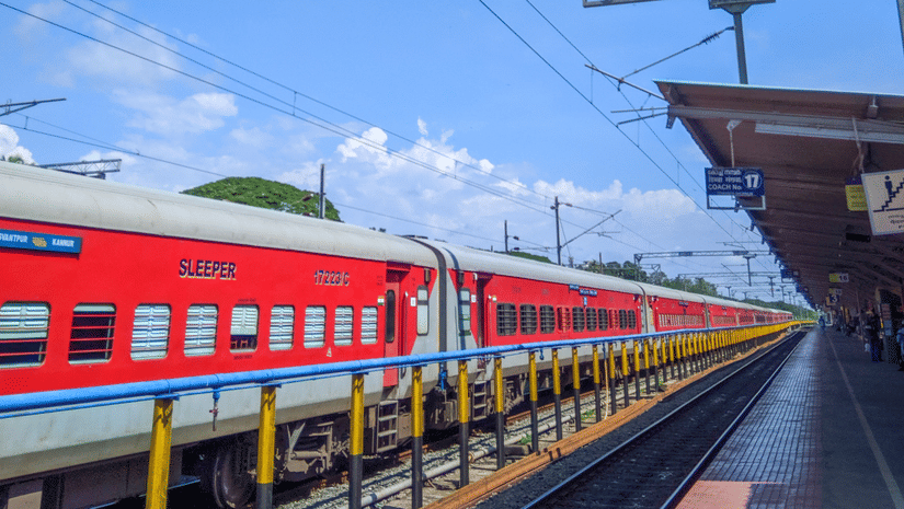 An Indian express train standing still by a platform on a railway station during the day time.
