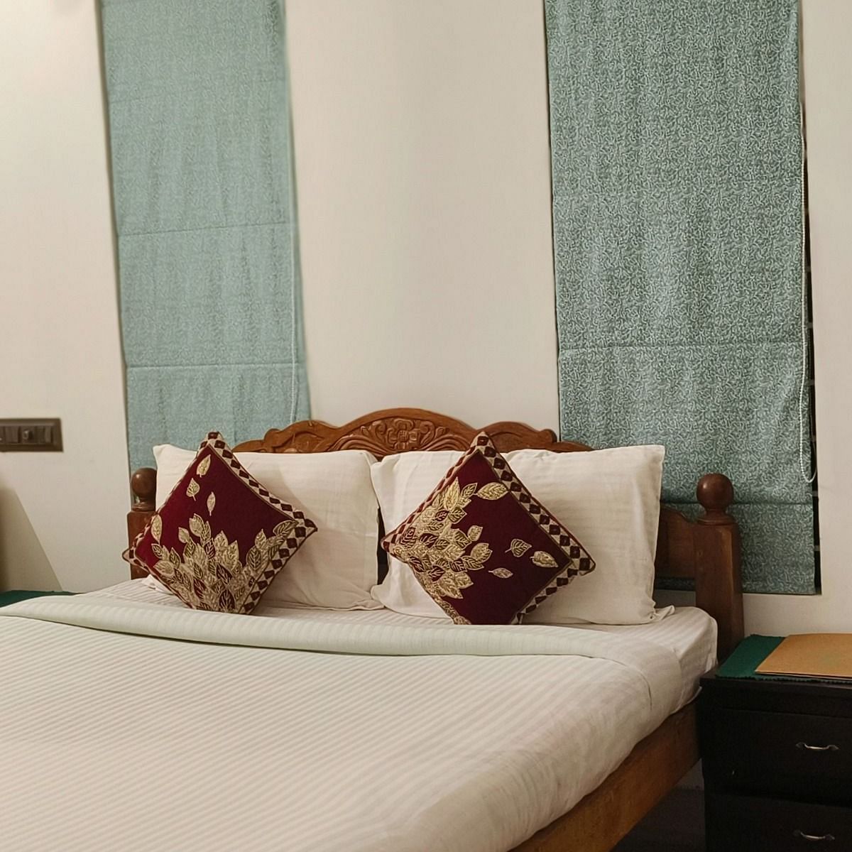 A zoomed in view of a double bed in the 104 room at Ananda Holiday Home, Wayanad 2