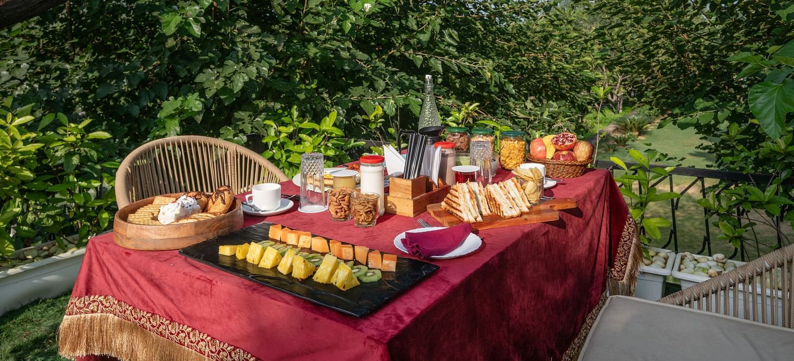 A table filled with food set in an outdoor space surrounded by lush plants at Valley by Grassfield.