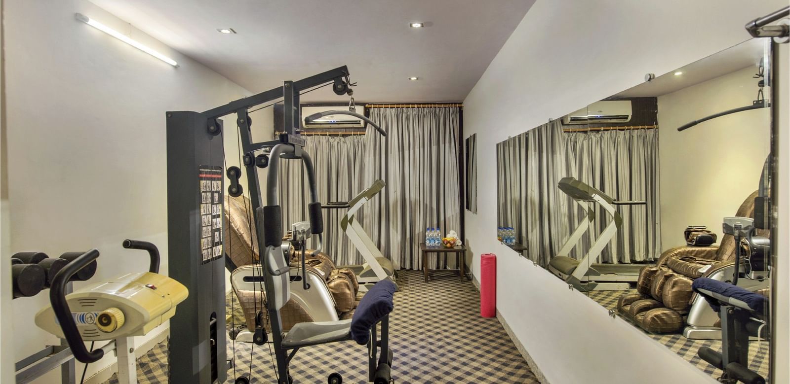 Fully equipped fitness centre at Lords Eco Inn Dahej featuring cardio and strength training equipment.