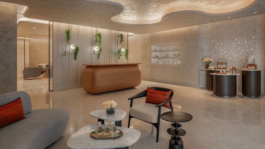 Spa reception and lounge area with seating, a reception desk and ambient lighting at The Residency Signature Madurai.