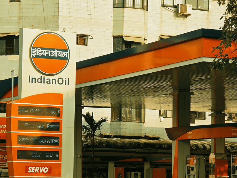 An Indian Oil petrol pump with its orange and white placard and the shades of orange and blue.