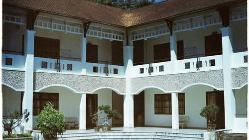 A colonial-style building with white arches and balconies, possibly a school or cultural institution.