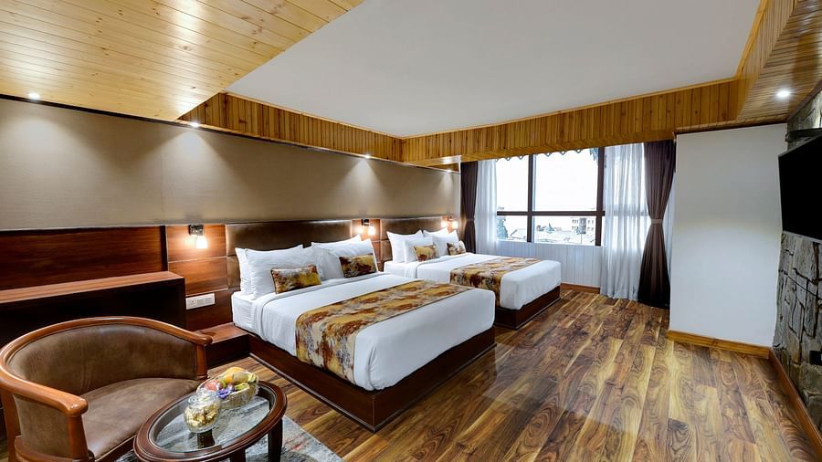 Image of Premium Family Room with a sitting area, two beds and window in the corner at Yashshree Mall Road, Darjeeling.