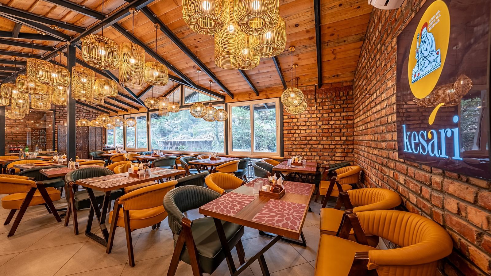 Interiors of the Kesari Restaurant with a well arranged seating area along with a LED screen featuring the name of the restaurant.