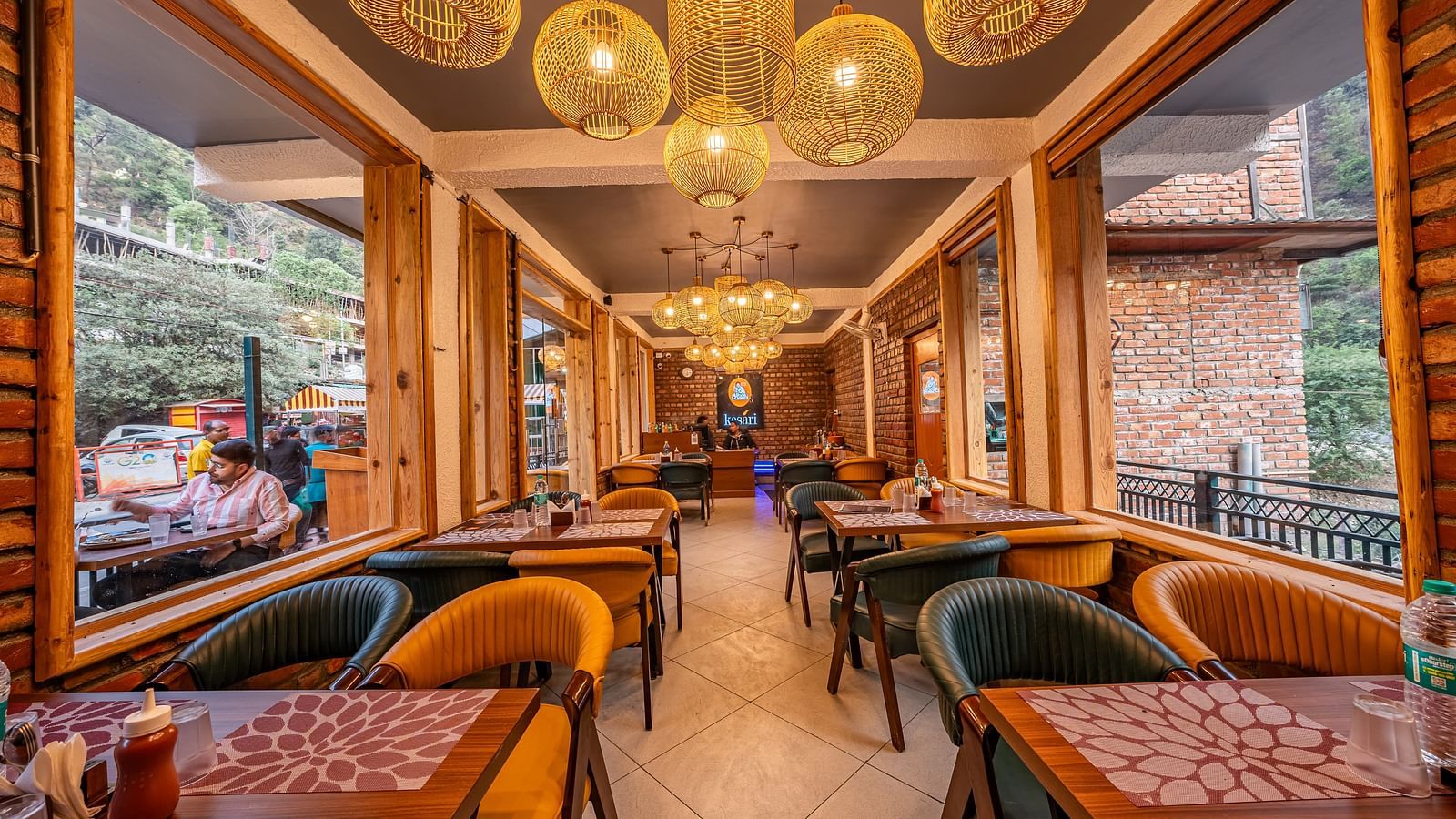 Cosy interiors of the Kesari Restaurant by JVR Stays featuring well arranged dining area with table mats placed on the tables.