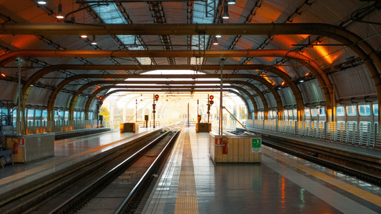 Empty railway platform inside a covered station with arched ceiling
