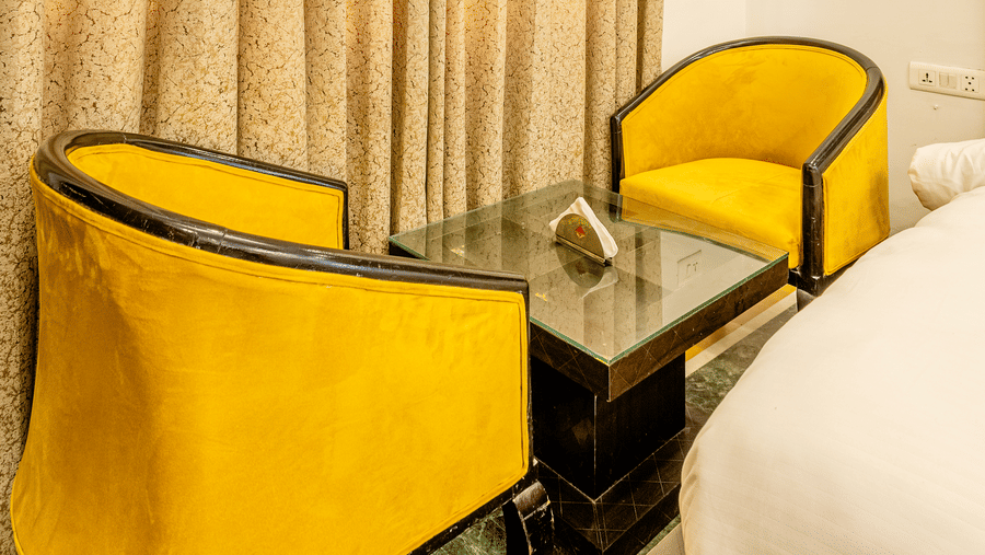 Cozy seating corner by the window in a well-appointed hotel room.